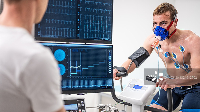 医生在实验室监测运动员在动感单车上的生物测试图片素材