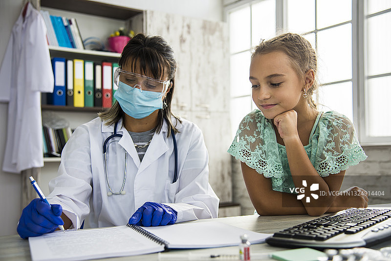 医生为女孩接种疫苗，将COVID-19疫苗注射到患者手臂图片素材