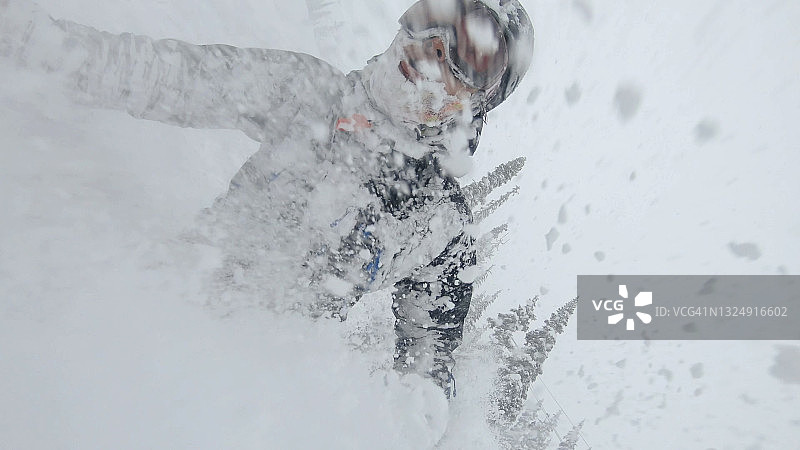 滑雪者在厚厚的粉雪中滑下雪坡图片素材