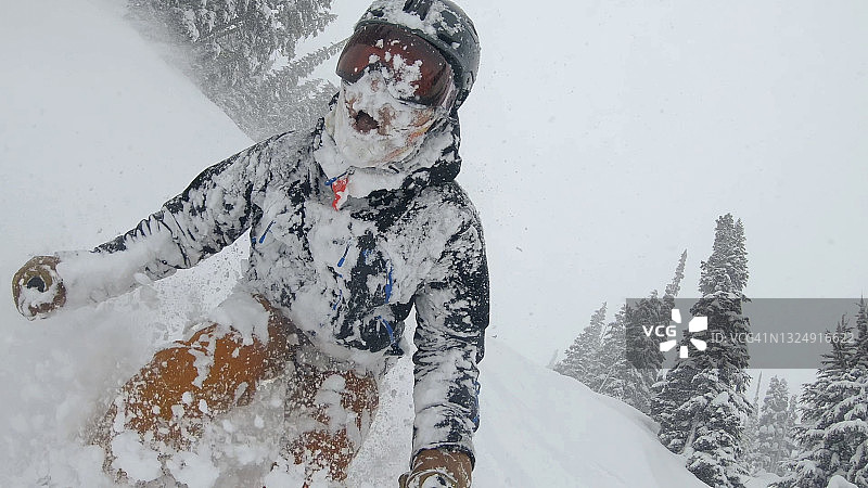 滑雪者在厚厚的粉雪中滑下雪坡图片素材