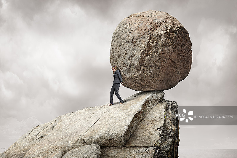 女人将大石头从悬崖上推下图片素材