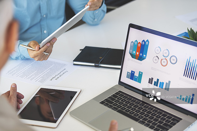 特写：商务人士在笔记本电脑上处理财务数据图片素材