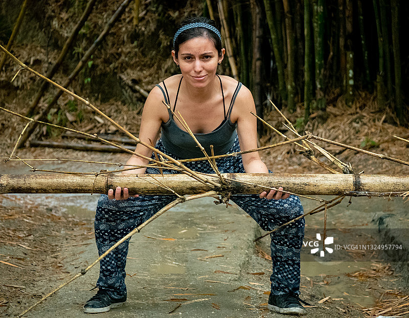 拉丁妇女在哥伦比亚明卡的干燥道路上举起一根竹子图片素材