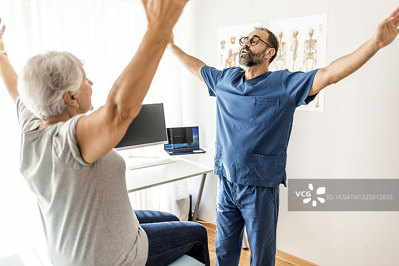为老年妇女客户进行康复理疗的现代理疗师图片素材