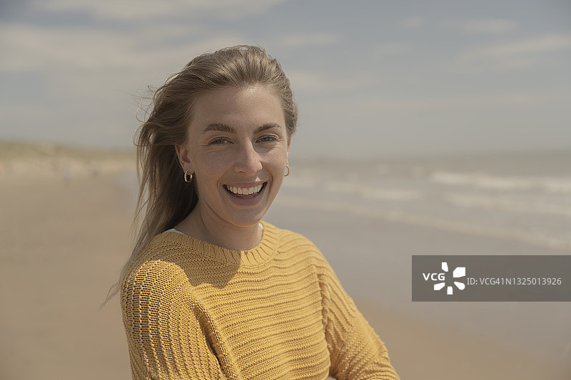 在海滩享受快乐时光的年轻女子肖像图片素材