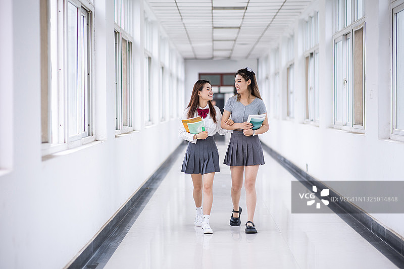 大学生和朋友边走边聊图片素材