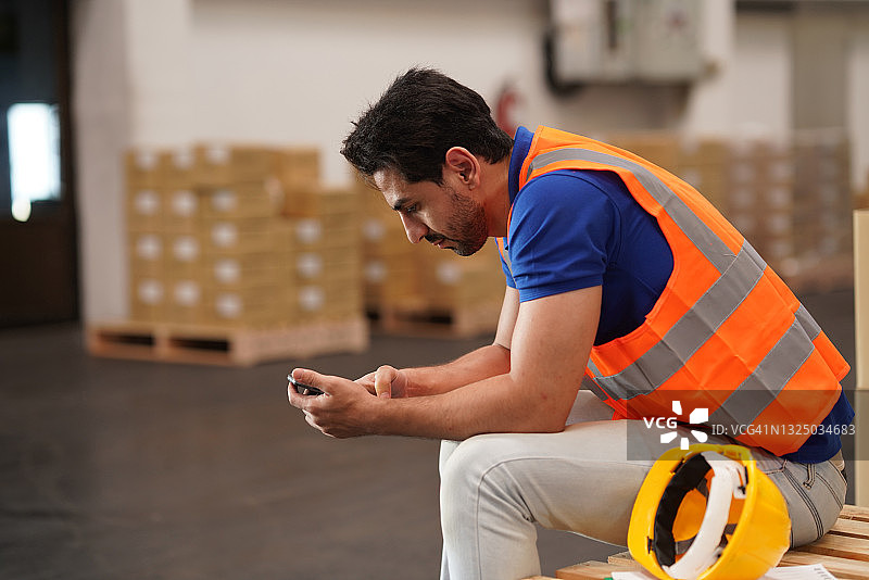 休息期间用手机上网的仓库工人图片素材