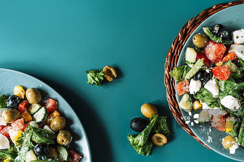 绿色盘子上装的两份希腊沙拉图片素材