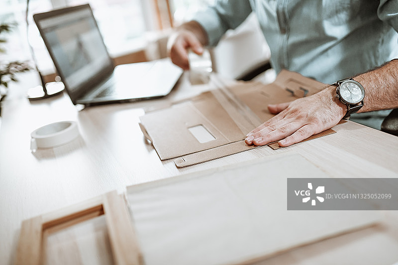 男人用胶带固定纸板包装图片素材