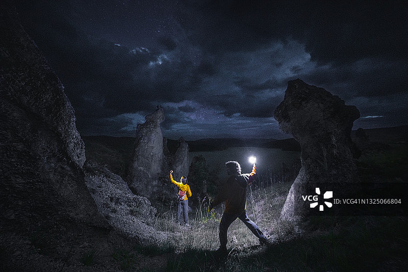 夜晚在石林中寻宝的两人图片素材