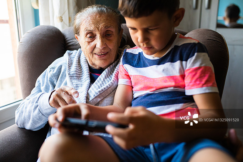 一个男孩教他的曾祖母使用科技产品图片素材