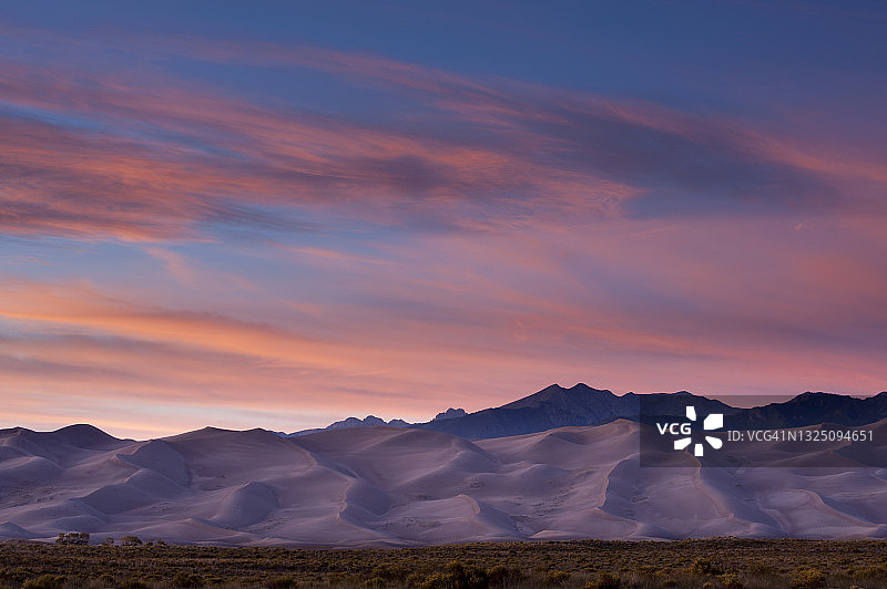 日落时分的大沙丘和山脉，美国科罗拉多州阿拉莫萨大沙丘国家公园图片素材