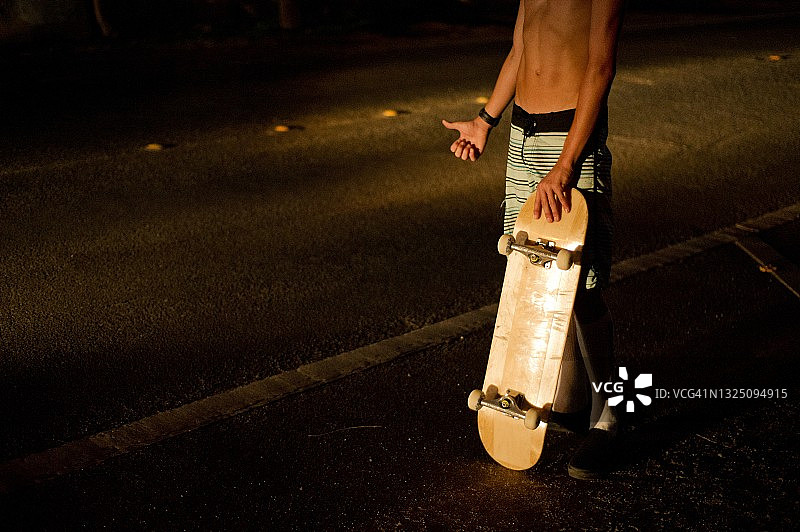 滑板运动员在夜间搭便车图片素材