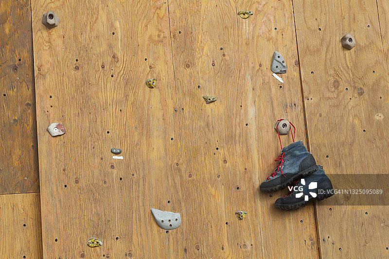 老式攀岩鞋挂在阿拉斯加州楚吉亚克家庭农场的自制攀岩墙上图片素材