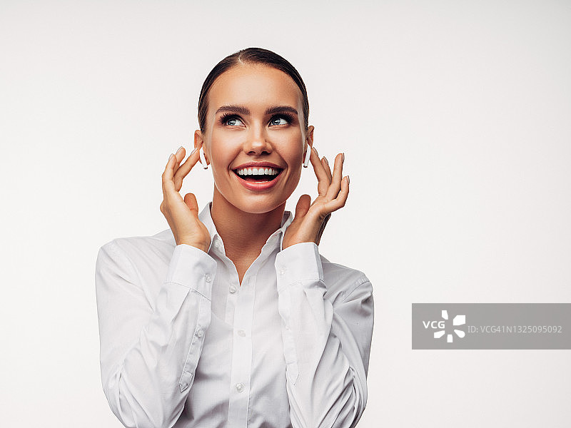 穿着白衬衫和无线耳机商务女孩的头像照片图片素材