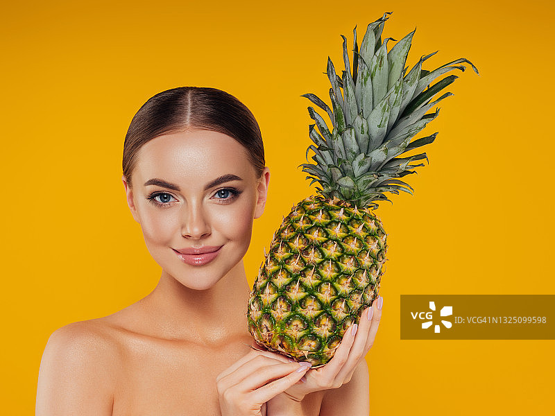 手持菠萝的美丽女孩图片素材