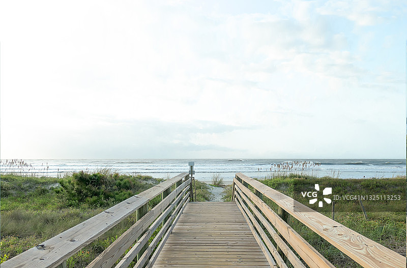从海滨别墅到海岸线的沙丘上的私人木板路，天空广阔图片素材
