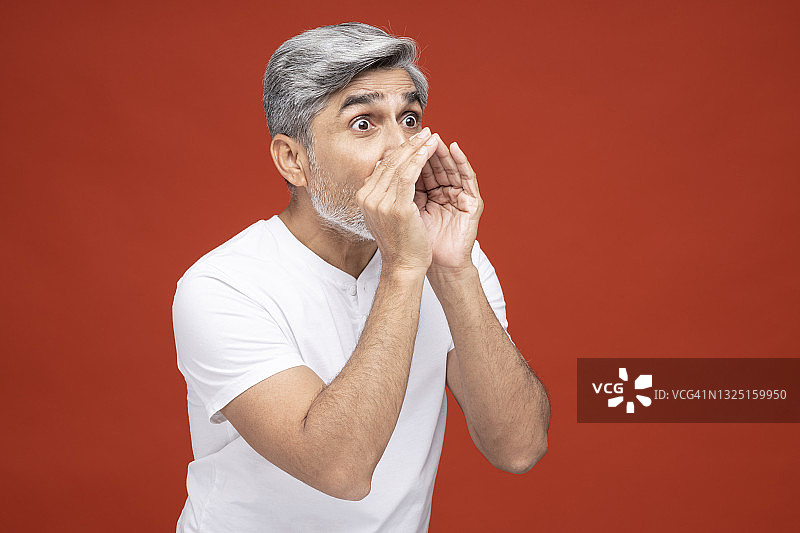 红色背景下的英俊成熟男人肖像图片素材