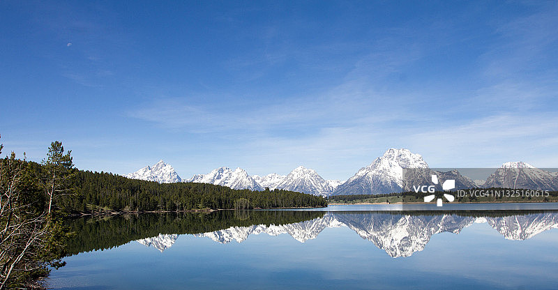 怀俄明州大提顿国家公园珍妮湖中倒映的雪山图片素材