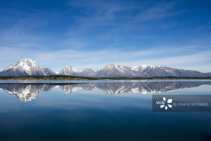 怀俄明州大提顿国家公园珍妮湖中倒映的雪山图片素材
