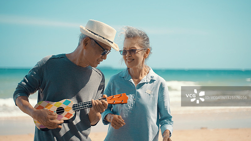 夏日傍晚，一对中年夫妇在海滩上伴着夕阳跳舞图片素材