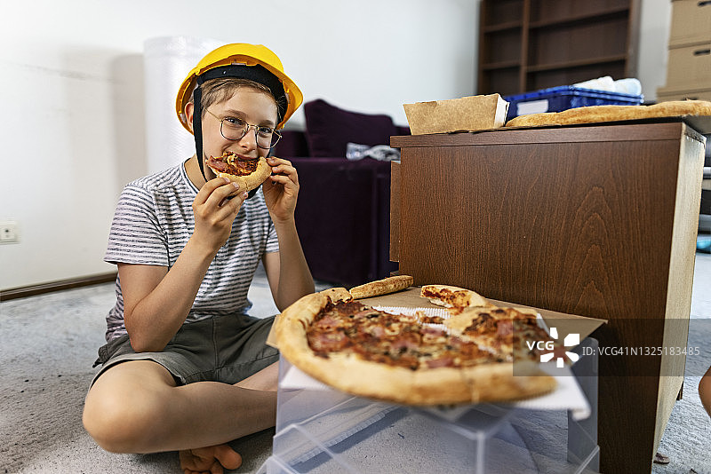 家庭装修期间吃披萨的小工人图片素材