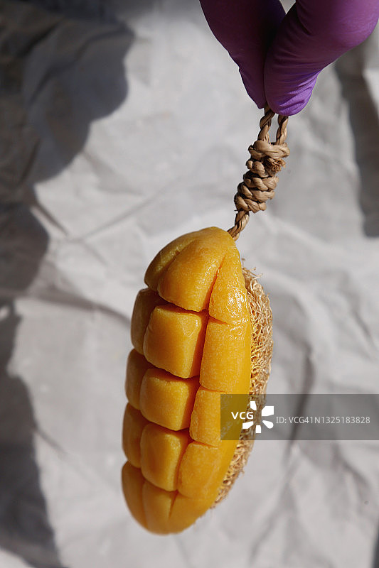 棕色纸背景上的自制芒果皂和有机海绵图片素材