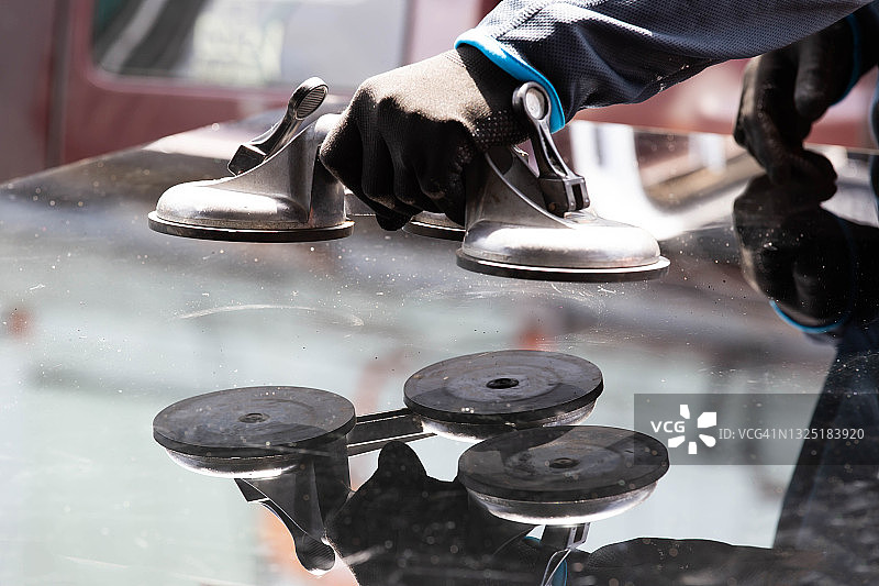 用于安装的吸盘，玻璃技术人员正在用吸盘组装玻璃柜。图片素材