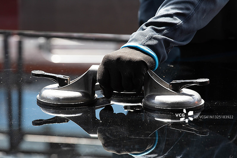 用于安装的吸盘，玻璃技术人员正在用吸盘组装玻璃柜。图片素材