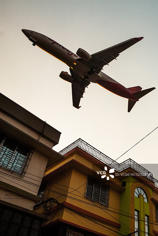 飞机飞过民宅上空图片素材