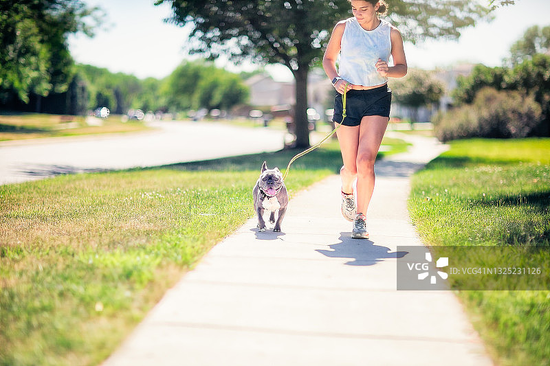 少女和法国斗牛犬在跑步图片素材