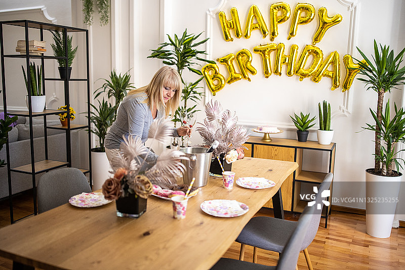年长的女人在家布置生日庆祝餐桌图片素材