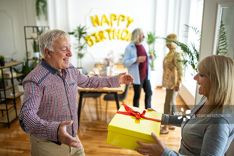 年长的女人到达朋友的生日派对并赠送礼物图片素材