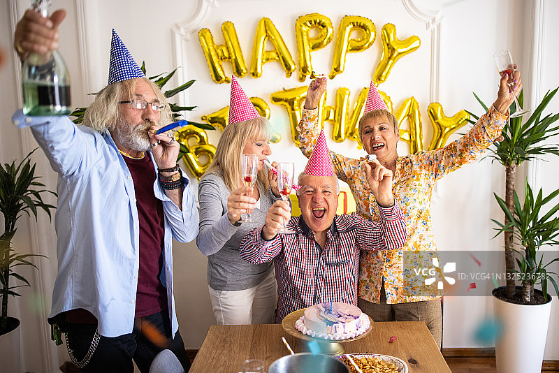 在家一起享受生日派对的老年朋友图片素材