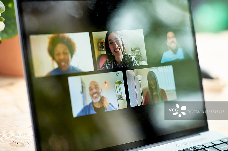 视频通话中笔记本电脑屏幕上的微笑表情图片素材