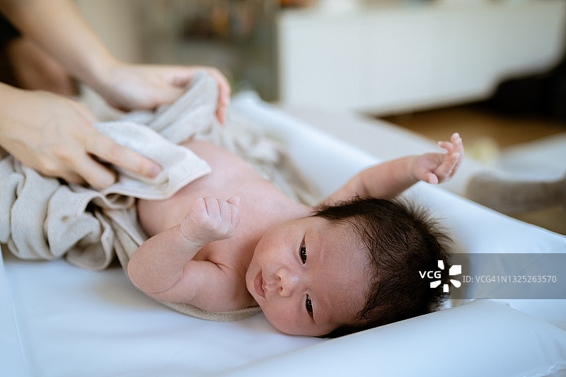 母亲在给新生儿洗澡前脱衣服图片素材