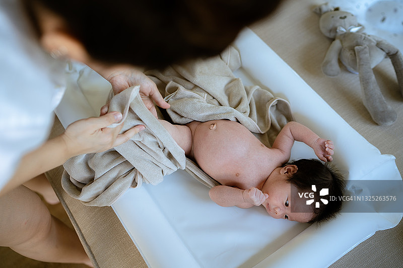 妈妈用毛巾擦干宝宝洗澡后的身体图片素材