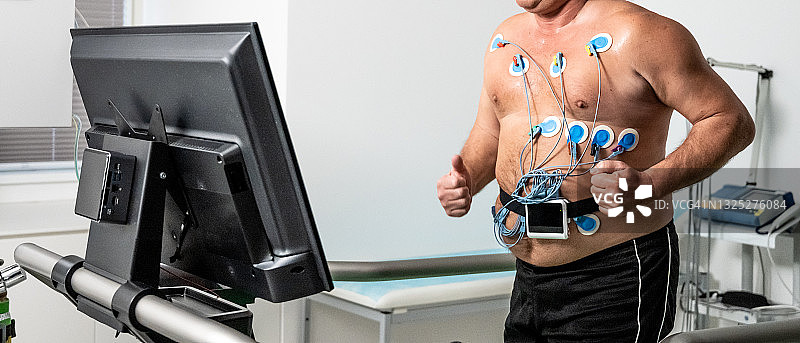 超重男子在跑步机上进行生物测试图片素材