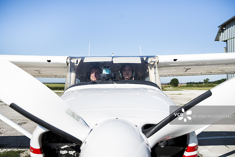 年轻女商人与飞机驾驶员谈论飞行情况图片素材