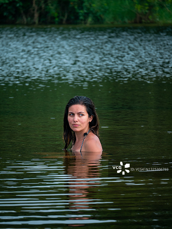 在哥伦比亚瓜希拉省帕洛米诺的圣萨尔瓦多河中游泳的焦虑拉丁裔女子图片素材