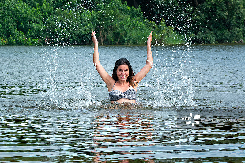 拉丁裔女人在哥伦比亚瓜希拉省帕洛米诺的圣萨尔瓦多河中戏水图片素材