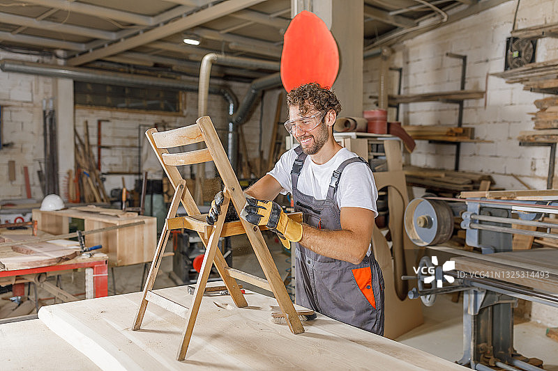 木匠在工作室修理旧木椅图片素材