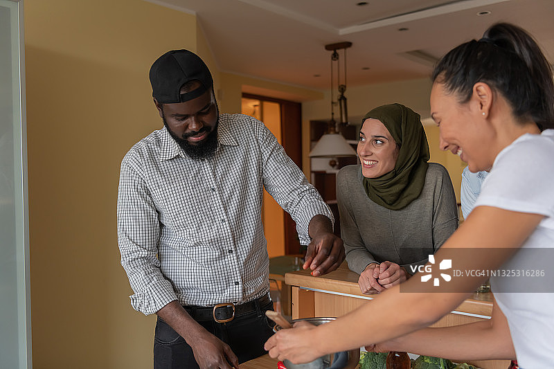 一群快乐的年轻多元文化朋友在厨房准备新鲜蔬菜晚餐图片素材