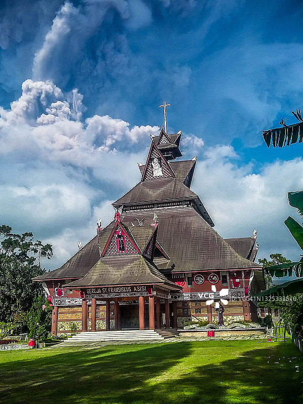 传统卡罗房屋风格的天主教堂，背景是壮丽的云彩图片素材