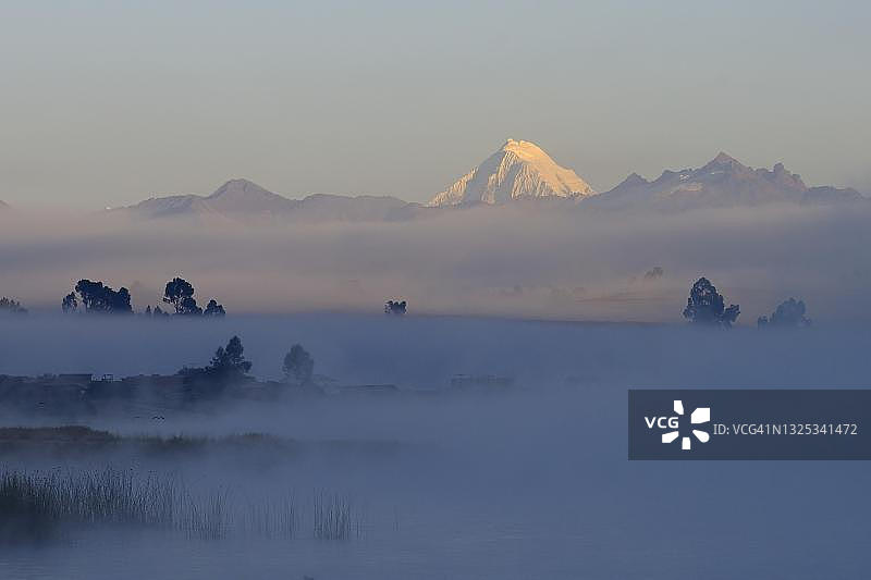 秘鲁乌鲁班巴省钦切罗附近，皮乌赖湖和安第斯山脉雪峰的晨雾图片素材