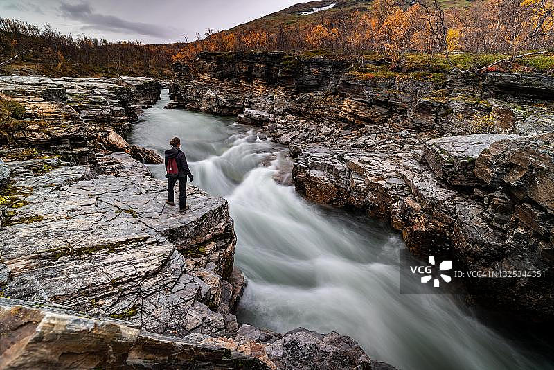 站在瑞典阿比斯库峡谷和河流旁的女人图片素材