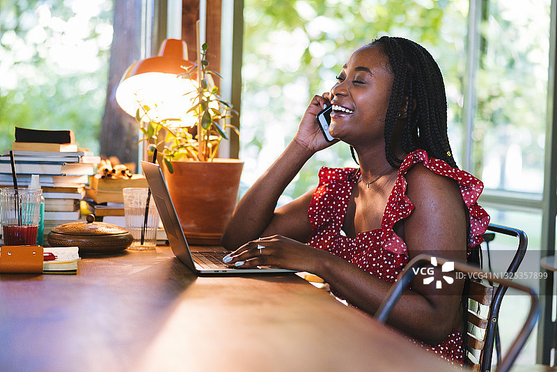 女孩打电话并使用笔记本电脑图片素材