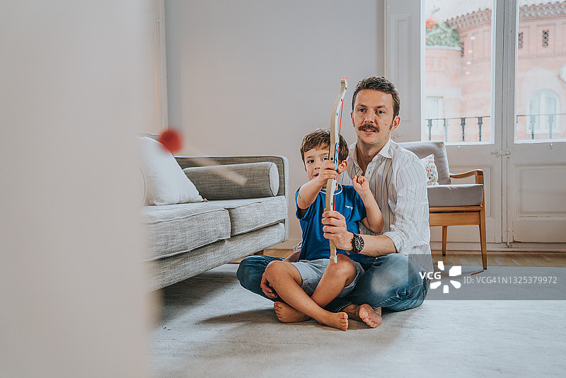 父亲和儿子玩射箭游戏图片素材