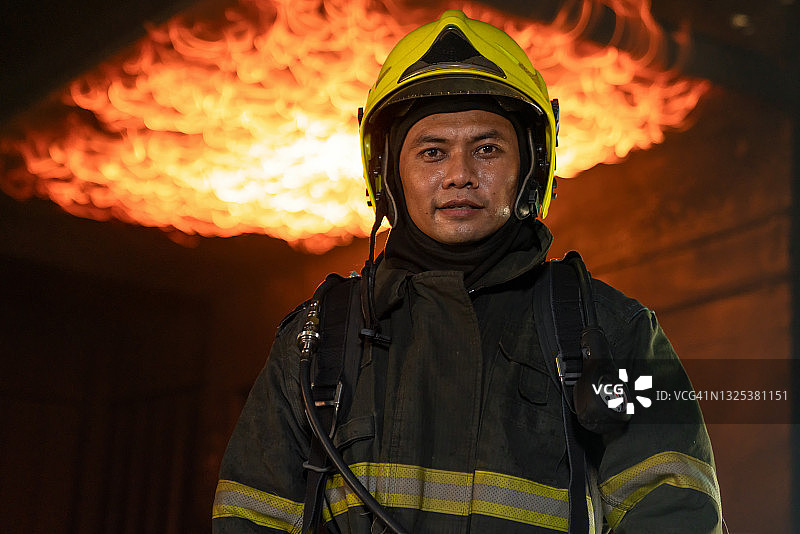 站在防火墙前的消防员，他站在室内发光的防火墙前图片素材