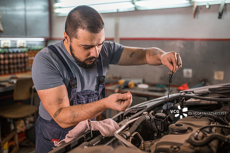 汽车修理工在汽车修理店修理发动机图片素材